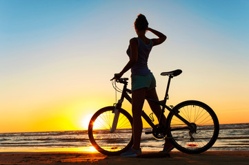 Obraz premium Moment in time. Sporty woman cyclist silhouette on multicolored