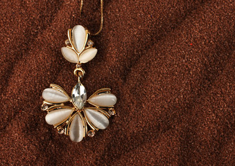 Golden Jewelry pendant with nacre and diamonds on brown backgrou