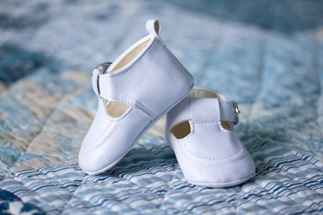 White baby shoes on a blanket