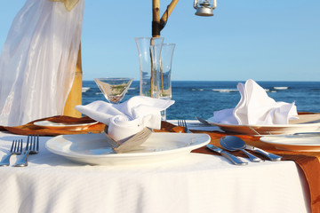 Blue sea and a table for a romantic dinner on the beach