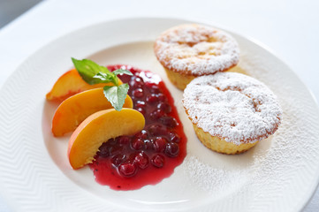 Curd cake with cranberry sauce and peach