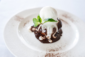 Chocolate cake with vanilla ice cream on white plate