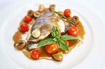 Dorado fillet in oyster sauce on white plate.