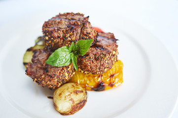 Filet mignon with grilled vegetables on white plate studio shot