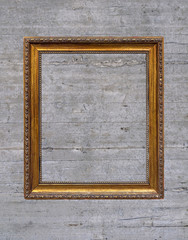 Vintage empty wooden frame hanged on concrete wall