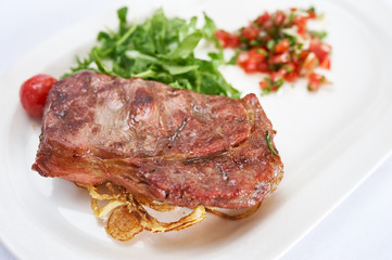 Grilled steak on white plate studio shot