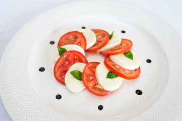 Caprese salad on white plate studio shot