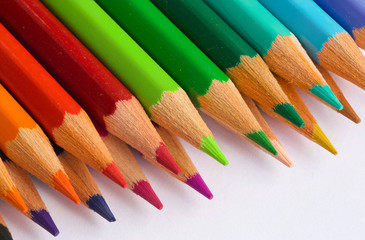 Colourful pencils on a white surface.Close up
