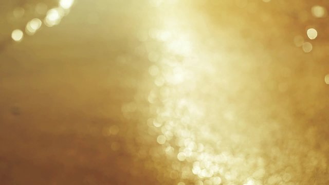 Beautiful blurred golden sea wave at sunset in slowmotion