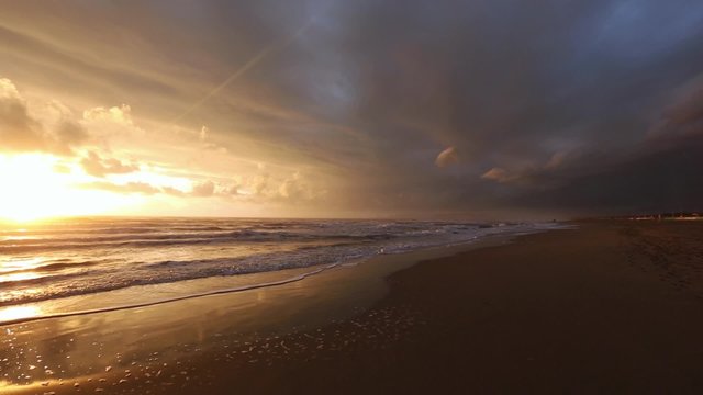 Sea beach sunset view with sun reflection on water and cloudy sky (Winter in Italy).

