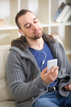 Smiling young man in headphones at home