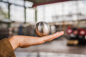 Metallkugel auf Hand balancieren