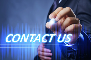 Businessman writing contact us on virtual screen. Internet and networking concept.