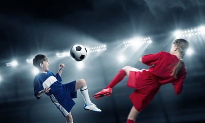 Kids play soccer on stadium 