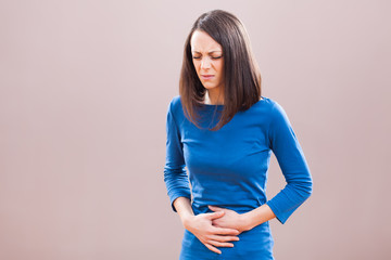 Portrait of young woman who is having pain in her stomach.