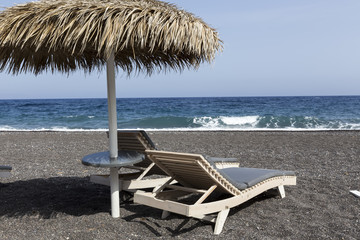 view of Perissa beach on the Greek island of Santorini with sunb