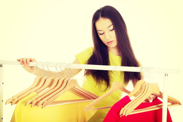 Beautiful woman thinking what to dress.