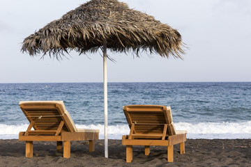 view of Perissa beach on the Greek island of Santorini with sunb