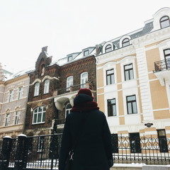 Girl looks on old building