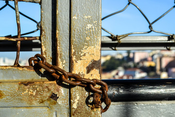 Old iron door closed by  a rusty chain