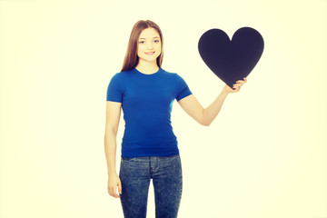 Happy teenager holding paper heart.