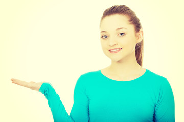 Smiling woman showing something on palm.