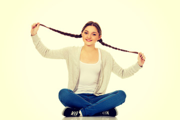 Happy teen woman sitting cross legged.