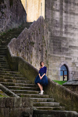 girl posing in blue dress standing on stone stairs