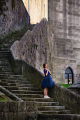 girl posing in blue dress standing on stone stairs