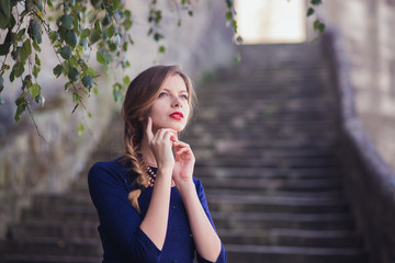 Fototapeta na wymiar girl posing in blue dress standing on stone stairs