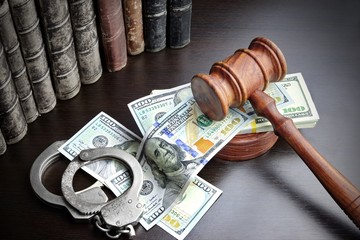 Judges Gavel, Handcuffs, Dollar Cash And Book On  Black Table