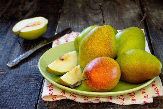 Fresh juicy pears on the dark wooden table