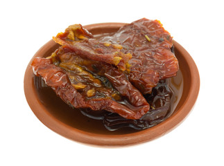 Sun dried tomatoes with olive oil in small dish