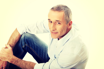 Fototapeta premium Mature man sitting on the floor