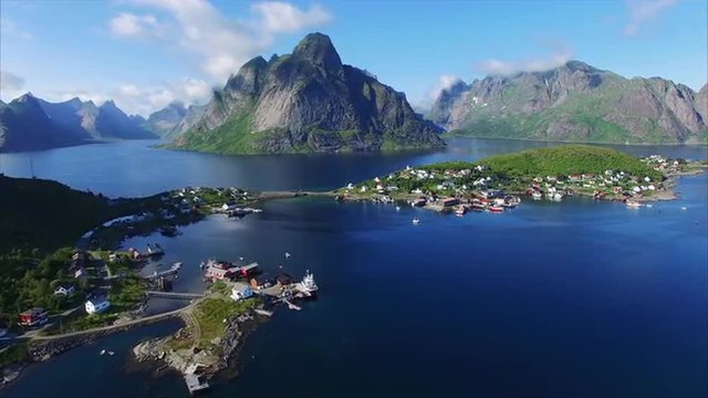 Aerial footage of fishing town Reine on Lofoten islands in Norway, popular tourist destination on sunny summer day. Aerial 4k Ultra HD.