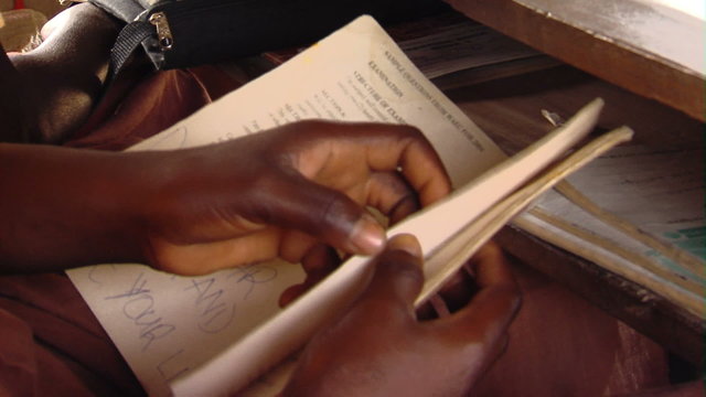 African girl turning the pages in her book.