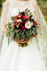 Very beautiful wedding bouquet in hands of the bride