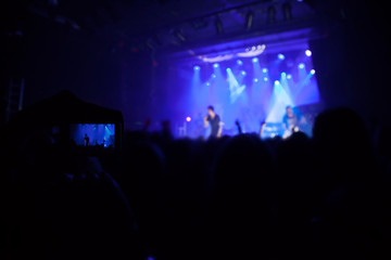 Silhouettes of people and musicians in big concert stage