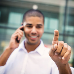 Handsome businessman pointing finger to camera and slicking virtual button, finger is in focus while his face is out of focus. Shallow depth of field.