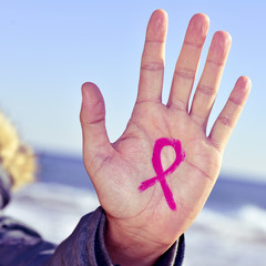 young man with a pink ribbon for the fight against cancer in his