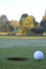 Golf ball beside the hole