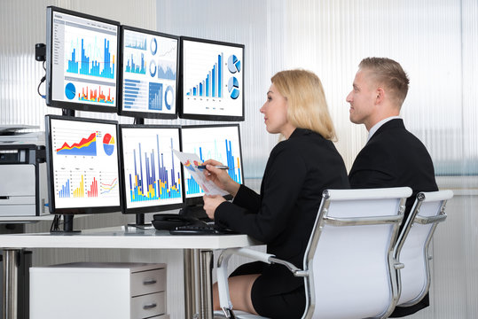 Financial Analysts Using Computers In Office