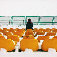 Girl sitting on a chair at the local stadium