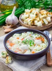 Homemade soup with meatballs and vegetables, served with cheese-garlic-parsley croutons