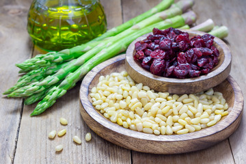 Ingredients for an appetizer with asparagus, pine nuts and cranberries