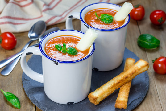 Homemade tomato basil soup in the mug, served with mozzarella cheese stick and croutons