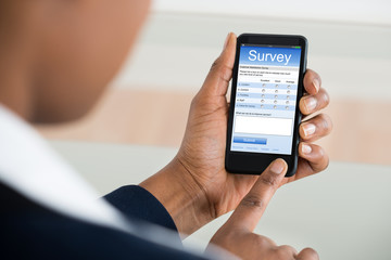 Businesswoman Filling Survey Form On Mobile Phone