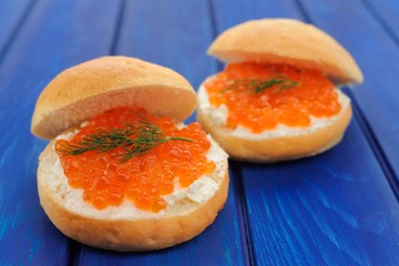 Delicious red caviar and green dill burgers on buns with cream c