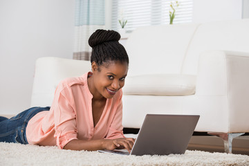 Woman Using Laptop On Carpet