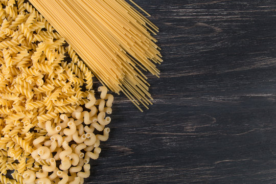 raw Italian pasta on a dark wooden background